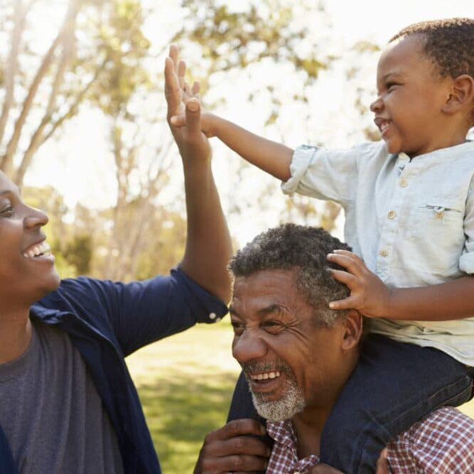 Grandfather With Son And Grandson Having Fun In Park